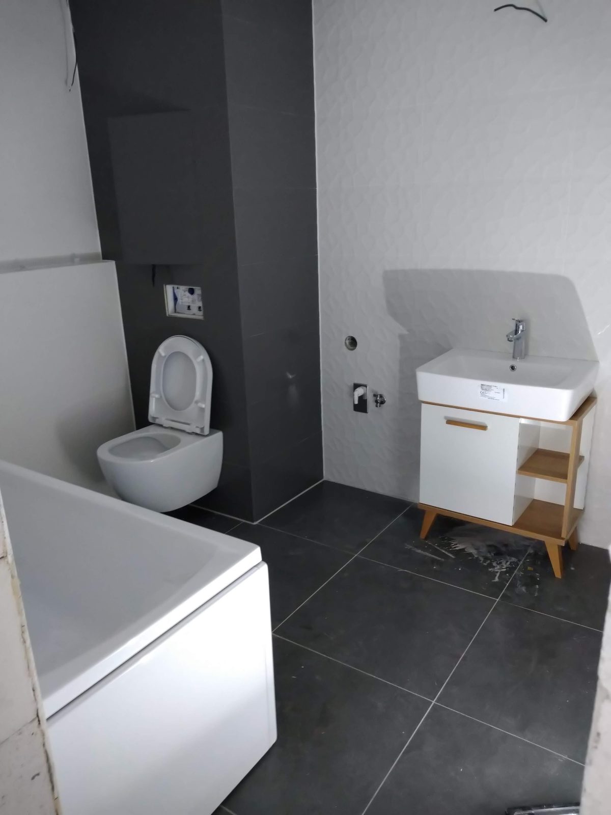 Dokončená kúpeľňa s vaňou, závesným WC a umývadlom so skrinkou